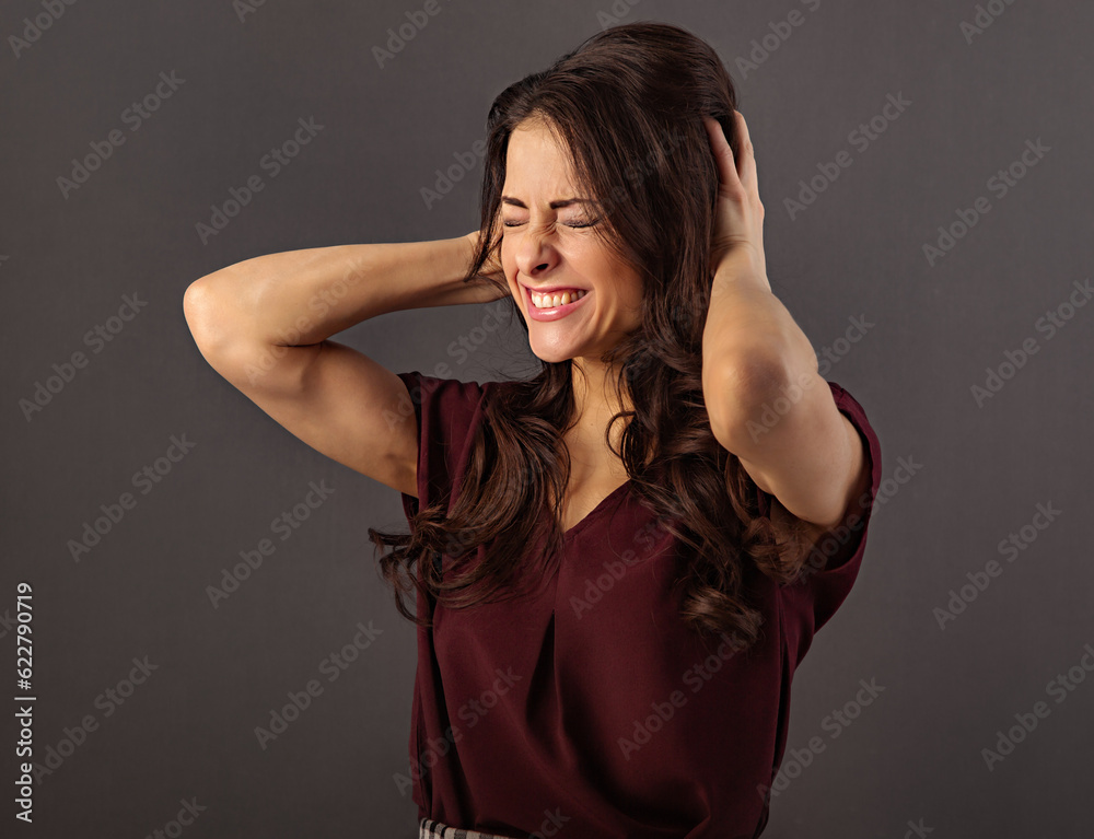 Emotional confused beautiful woman holding the head the hands with clenched her teeth and thinking hard question on grey background. Closeup Emotional confused beautiful woman holding the head the hands with clenched her teeth and thinking hard question on grey background. Closeup