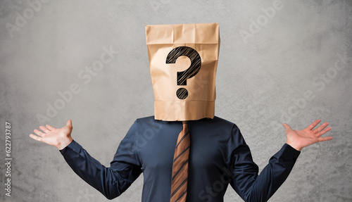 Fotografía Businessman wearing paper bag on head with a question mark concept