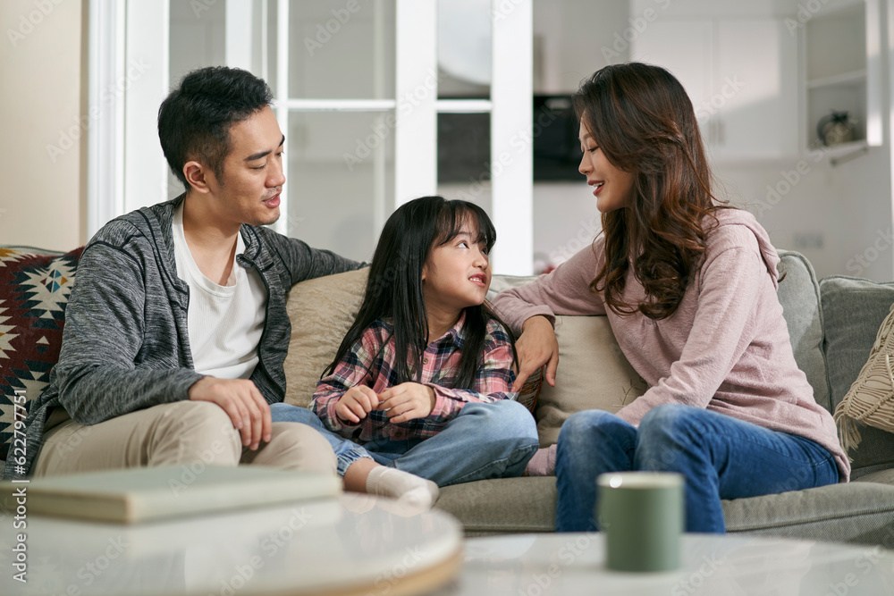 young asian couple having a pleasant conversation with daughter at home young asian couple having a pleasant conversation with daughter at home