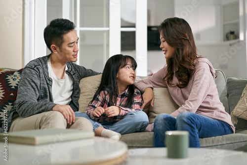 young asian couple having a pleasant conversation with daughter at home