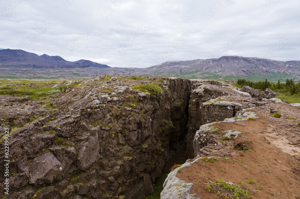 Beautiful nature in Iceland. Scenic Icelandic landscape at cloudy day. Hiking path in hollow between the stone rocks. No people.