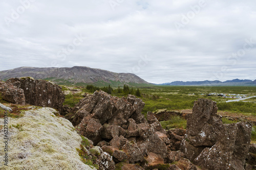 Beautiful nature in Iceland. Scenic Icelandic landscape at cloudy day. Hills, huge rocks, green grass.
