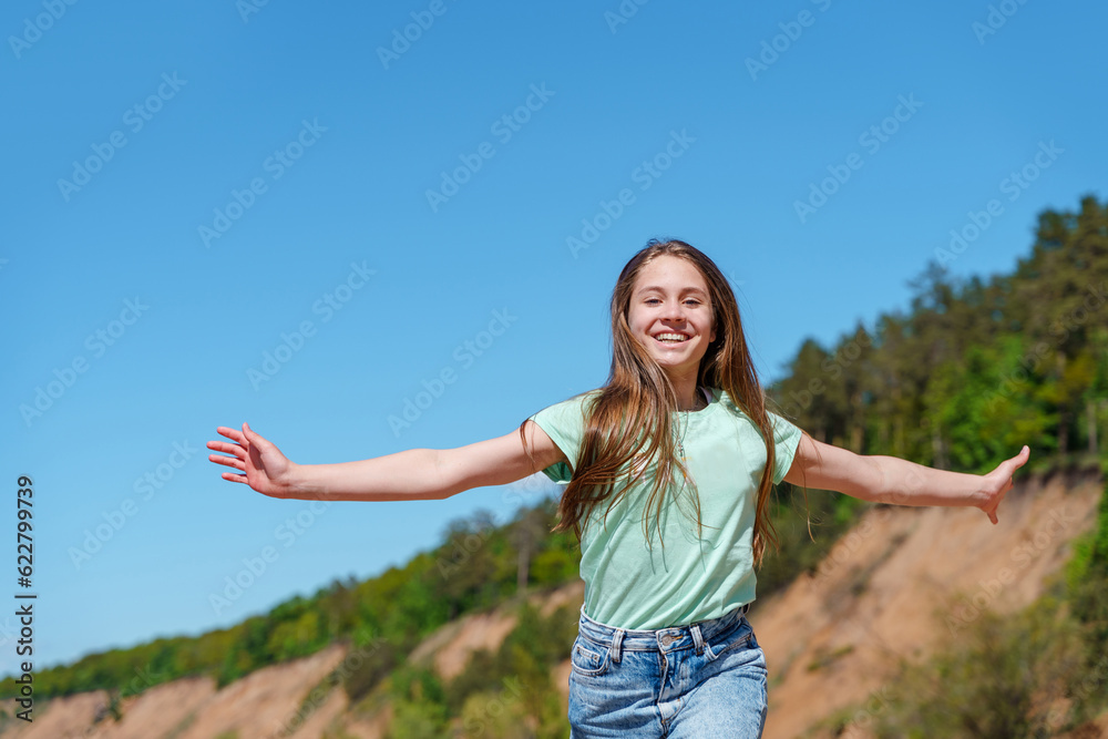 A teenage girl with long hair and jeans runs and frolics on the beach A teenage girl with long hair and jeans runs and frolics on the beach