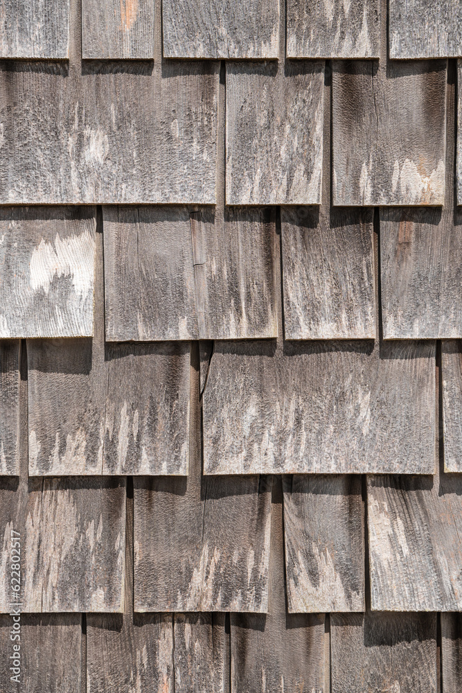 Close-up view of large gray weathered shingles on typical Cape Cod building in quaint fishing village on Martha's Vineyard, Massachusetts.
