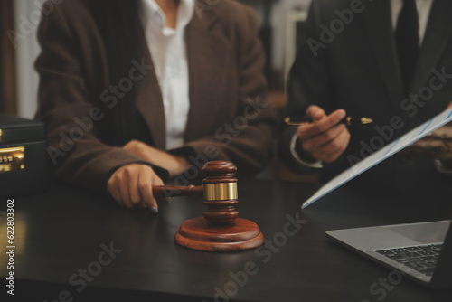 Business and lawyers discussing contract papers with brass scale on desk in office. Law, legal services, advice, justice and law concept picture with film grain effect