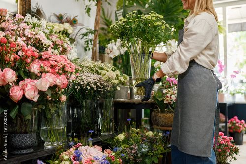 Woman florist small business owner standing in floral store. High quality photo