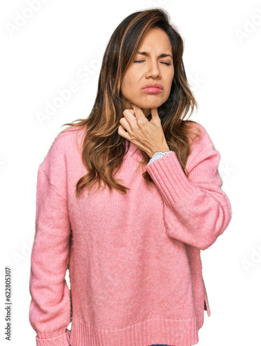 Young hispanic woman wearing casual clothes touching painful neck, sore throat for flu, clod and infection