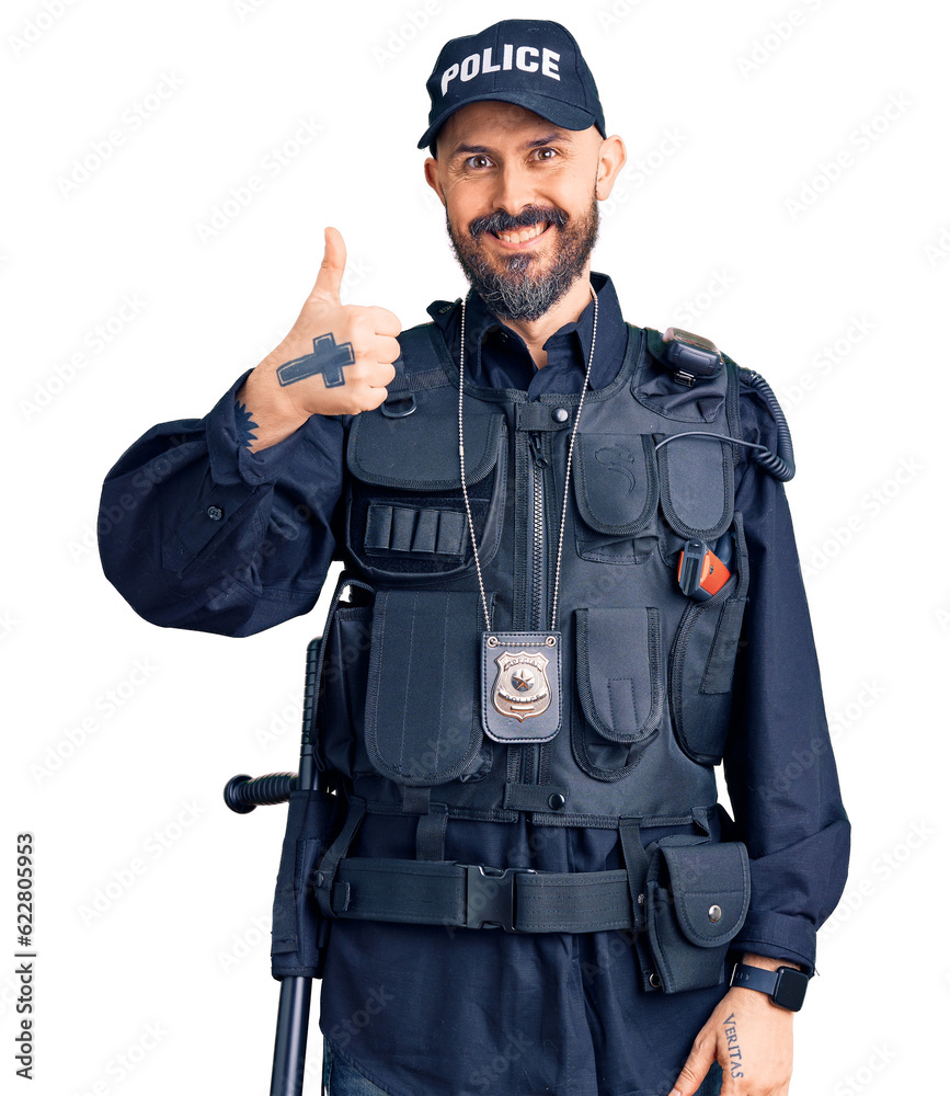 Young handsome man wearing police uniform doing happy thumbs up gesture with hand. approving expression looking at the camera showing success. Young handsome man wearing police uniform doing happy thumbs up gesture with hand. approving expression looking at the camera showing success.