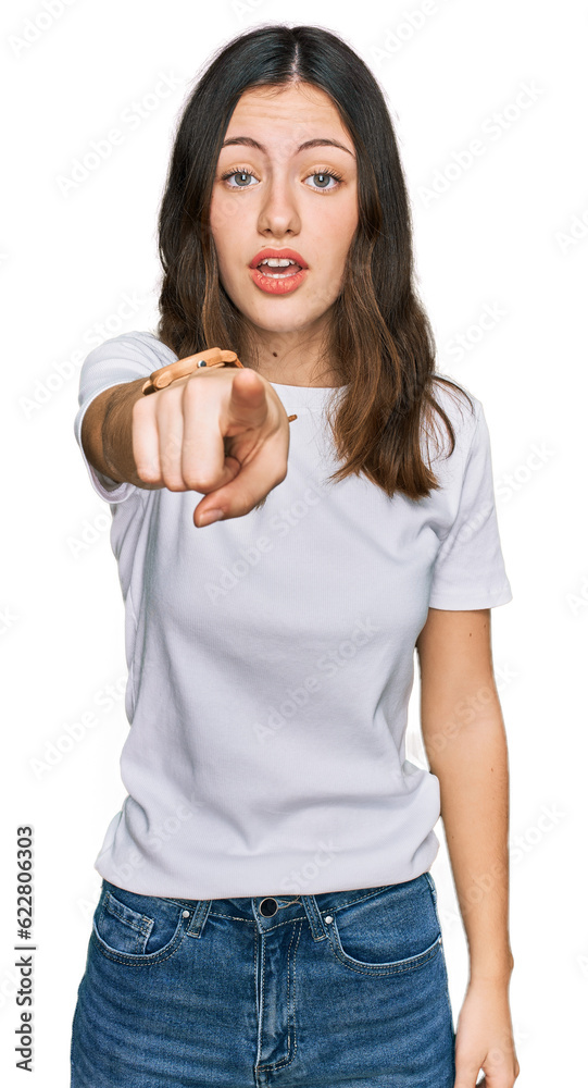Young beautiful woman wearing casual white t shirt pointing displeased and frustrated to the camera, angry and furious with you Young beautiful woman wearing casual white t shirt pointing displeased and frustrated to the camera, angry and furious with you