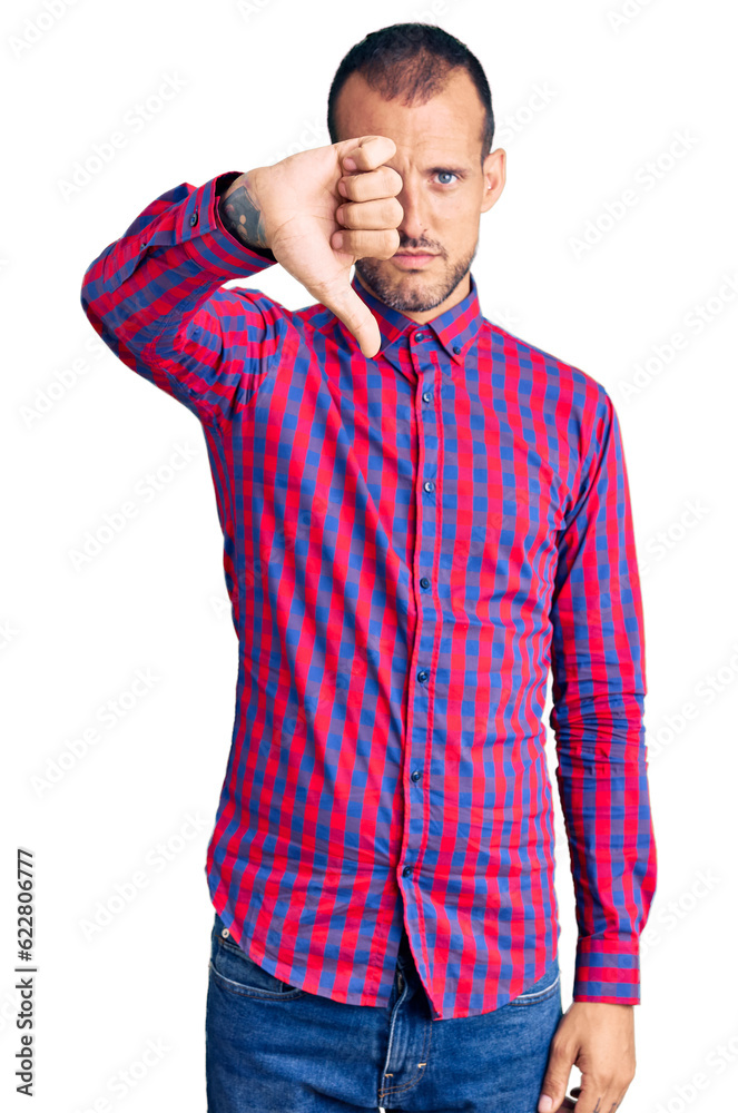 Young handsome man wearing casual clothes looking unhappy and angry showing rejection and negative with thumbs down gesture. bad expression.