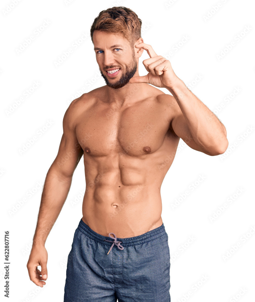 Young caucasian man standing shirtless smiling and confident gesturing with hand doing small size sign with fingers looking and the camera. measure concept. Young caucasian man standing shirtless smiling and confident gesturing with hand doing small size sign with fingers looking and the camera. measure concept.