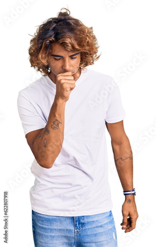 Young hispanic man wearing casual white tshirt feeling unwell and coughing as symptom for cold or bronchitis. health care concept.