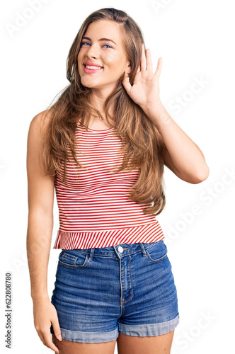 Beautiful caucasian young woman wearing casual clothes smiling with hand over ear listening an hearing to rumor or gossip. deafness concept.