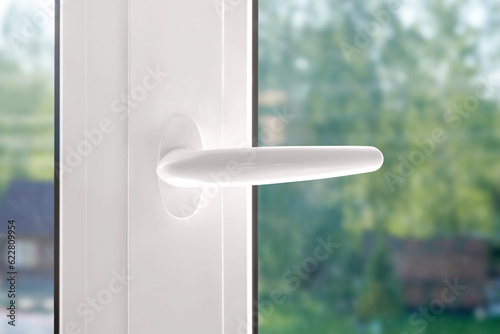 White plastic window handle. Plastic window furniture close-up.