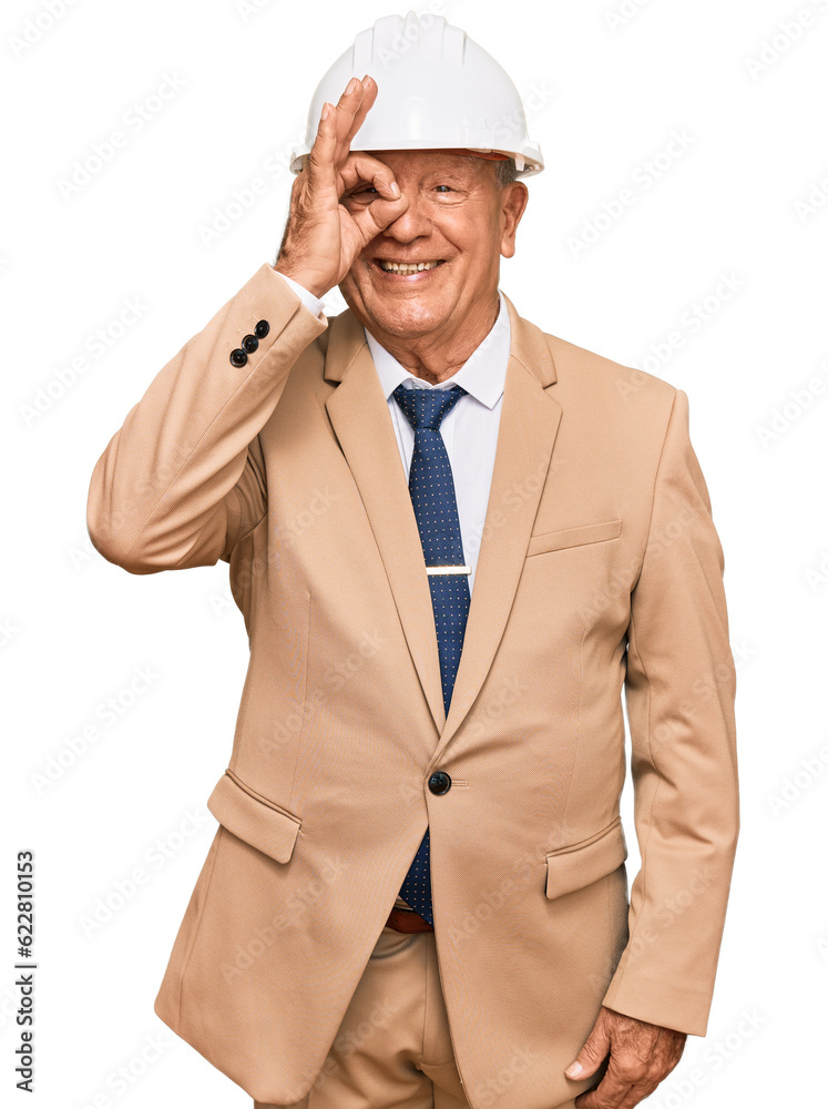 Senior caucasian man wearing architect hardhat smiling happy doing ok sign with hand on eye looking through fingers