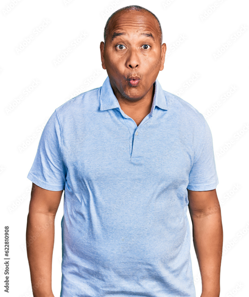 Hispanic middle age man wearing casual t shirt scared and amazed with open mouth for surprise, disbelief face Hispanic middle age man wearing casual t shirt scared and amazed with open mouth for surprise, disbelief face