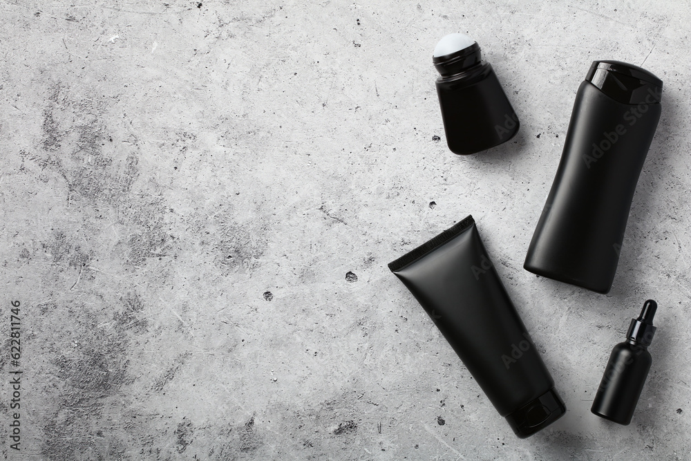 Premium men's cosmetics top view. Flat lay black shower gel tube, shampoo bottle, deodorant, serum on stone table. Premium men's cosmetics top view. Flat lay black shower gel tube, shampoo bottle, deodorant, serum on stone table.