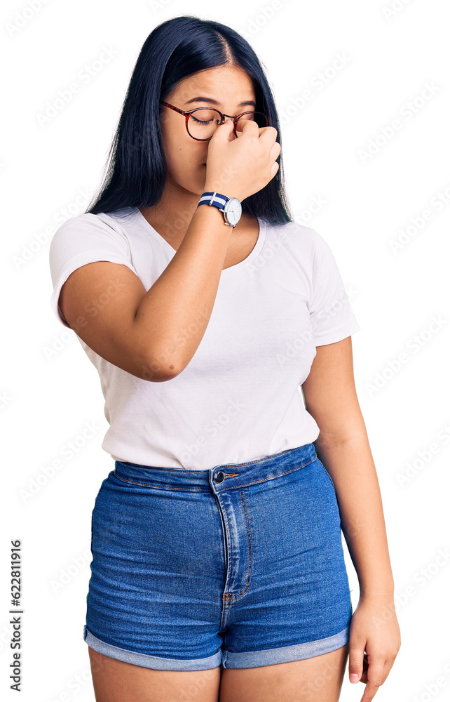 Young beautiful asian girl wearing casual clothes and glasses tired rubbing nose and eyes feeling fatigue and headache. stress and frustration concept. Young beautiful asian girl wearing casual clothes and glasses tired rubbing nose and eyes feeling fatigue and headache. stress and frustration concept.