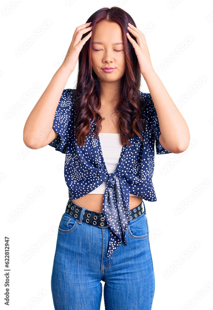 Young beautiful chinese girl wearing casual clothes with hand on head for pain in head because stress. suffering migraine. Young beautiful chinese girl wearing casual clothes with hand on head for pain in head because stress. suffering migraine.