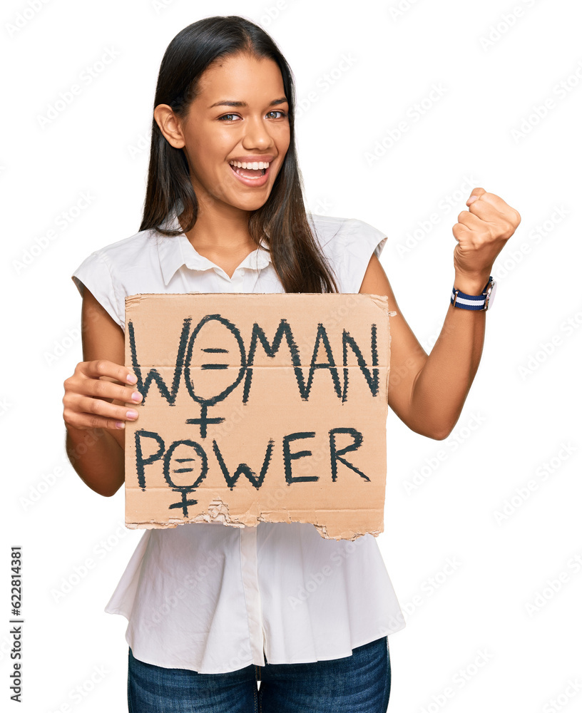 Beautiful hispanic woman holding woman power banner screaming proud, celebrating victory and success very excited with raised arms Beautiful hispanic woman holding woman power banner screaming proud, celebrating victory and success very excited with raised arms
