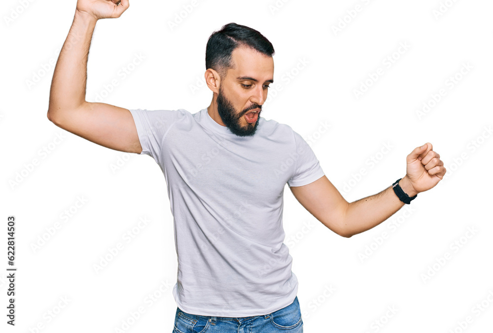 Young man with beard wearing casual white t shirt dancing happy and cheerful, smiling moving casual and confident listening to music