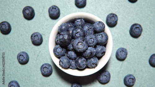 Fresh juicy blueberries on blue background, flat lay with copy space. Blueberries background. Concept of healthy nutrition, organic food. Vegan and vegetarian