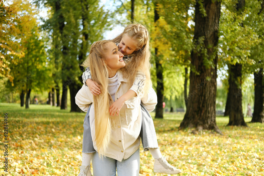 little child is having fun with her mother in city park, happy family life, kid girl on her back mom laughs, childish desires play, daughter love hug mom, laughing cheerful people on street glare sun little child is having fun with her mother in city park, happy family life, kid girl on her back mom laughs, childish desires play, daughter love hug mom, laughing cheerful people on street glare sun