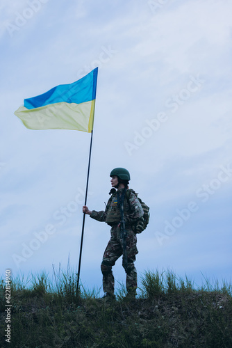 Portrait of Ukrainian female soldier holding a national flag