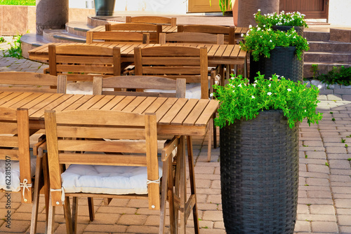 wooden furniture, tables and chairs of a cozy outdoor cafe on a clear sunny summer day. beautiful postcard for the designer. desktop background