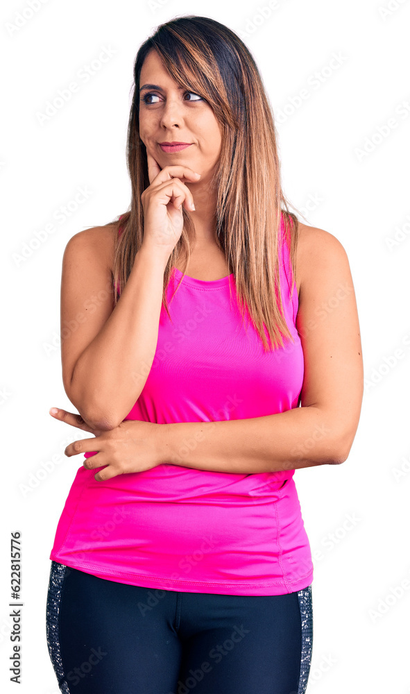Young beautiful woman wearing sportswear with hand on chin thinking about question, pensive expression. smiling with thoughtful face. doubt concept. Young beautiful woman wearing sportswear with hand on chin thinking about question, pensive expression. smiling with thoughtful face. doubt concept.