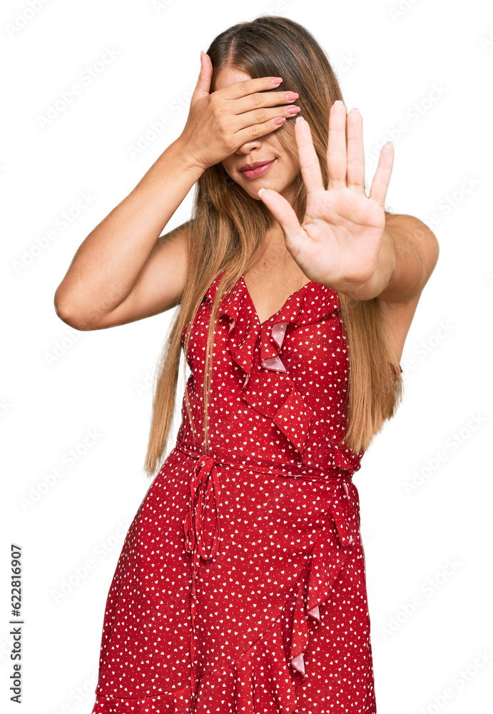 Beautiful blonde woman wearing summer dress covering eyes with hands and doing stop gesture with sad and fear expression. embarrassed and negative concept. Beautiful blonde woman wearing summer dress covering eyes with hands and doing stop gesture with sad and fear expression. embarrassed and negative concept.