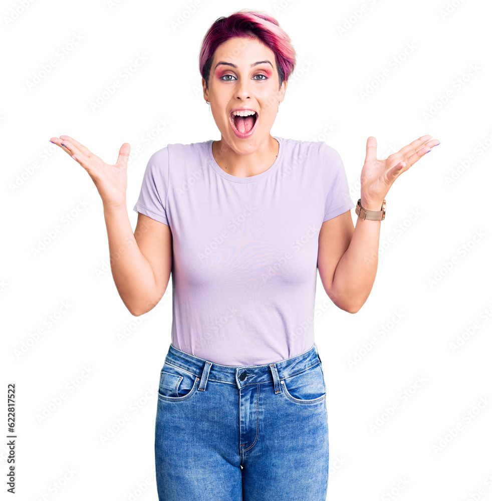 Young beautiful woman with pink hair wearing casual clothes celebrating crazy and amazed for success with arms raised and open eyes screaming excited. winner concept Young beautiful woman with pink hair wearing casual clothes celebrating crazy and amazed for success with arms raised and open eyes screaming excited. winner concept