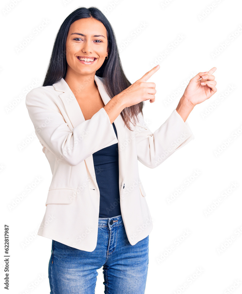 Young beautiful latin girl wearing business clothes smiling and looking at the camera pointing with two hands and fingers to the side. Young beautiful latin girl wearing business clothes smiling and looking at the camera pointing with two hands and fingers to the side.