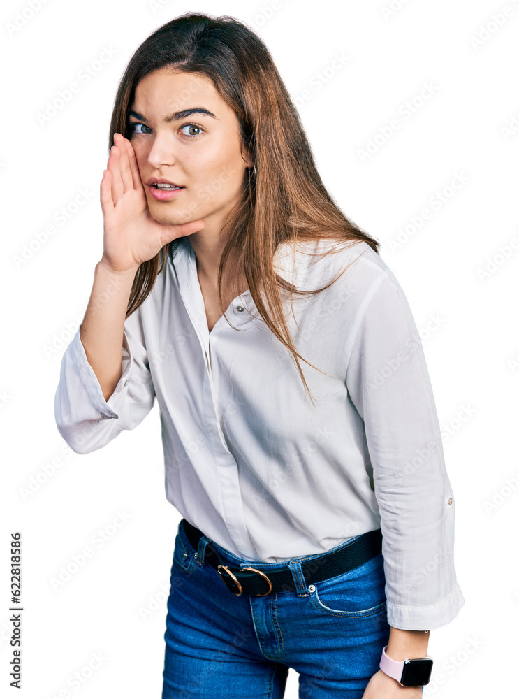 Young caucasian girl wearing casual white shirt hand on mouth telling secret rumor, whispering malicious talk conversation Young caucasian girl wearing casual white shirt hand on mouth telling secret rumor, whispering malicious talk conversation