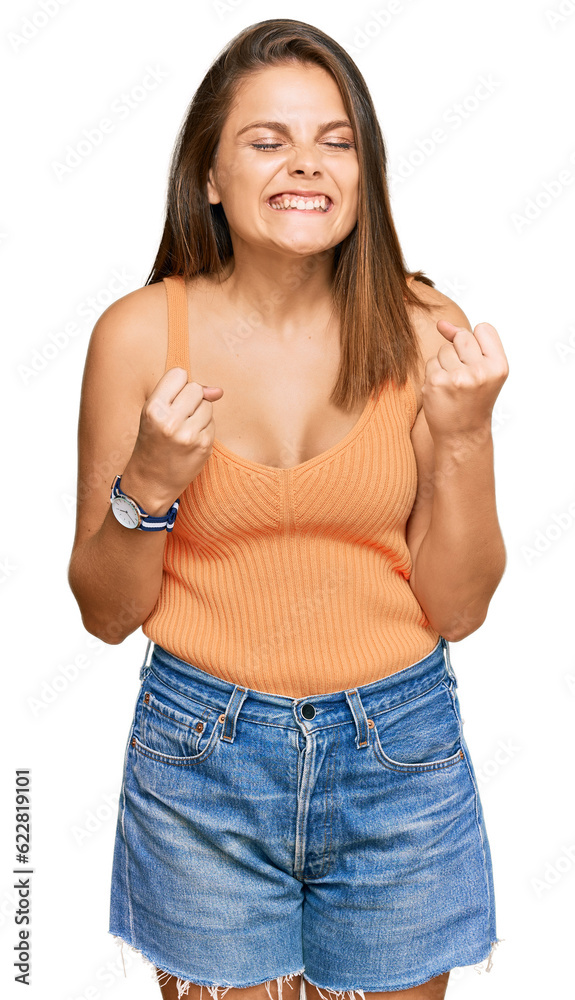 Young caucasian woman wearing casual clothes excited for success with arms raised and eyes closed celebrating victory smiling. winner concept. Young caucasian woman wearing casual clothes excited for success with arms raised and eyes closed celebrating victory smiling. winner concept.