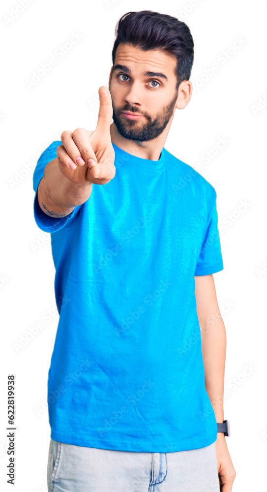 Young handsome man with beard wearing casual t-shirt pointing with finger up and angry expression, showing no gesture Young handsome man with beard wearing casual t-shirt pointing with finger up and angry expression, showing no gesture
