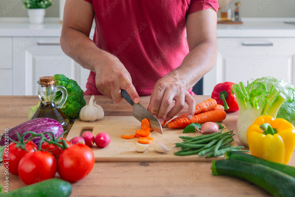 Man hands cutting vegetables in the kitchen Man hands cutting vegetables in the kitchen