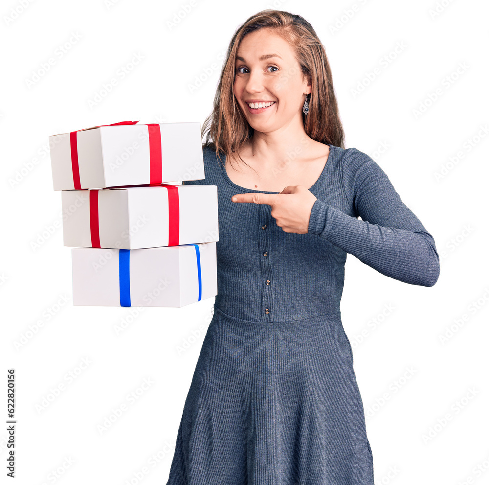 Young beautiful blonde woman holding birthday gift smiling happy pointing with hand and finger Young beautiful blonde woman holding birthday gift smiling happy pointing with hand and finger