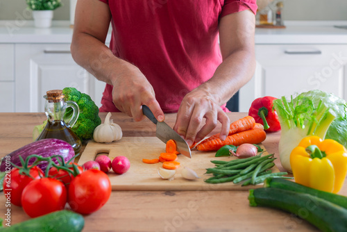 Man hands cutting vegetables in the kitchen