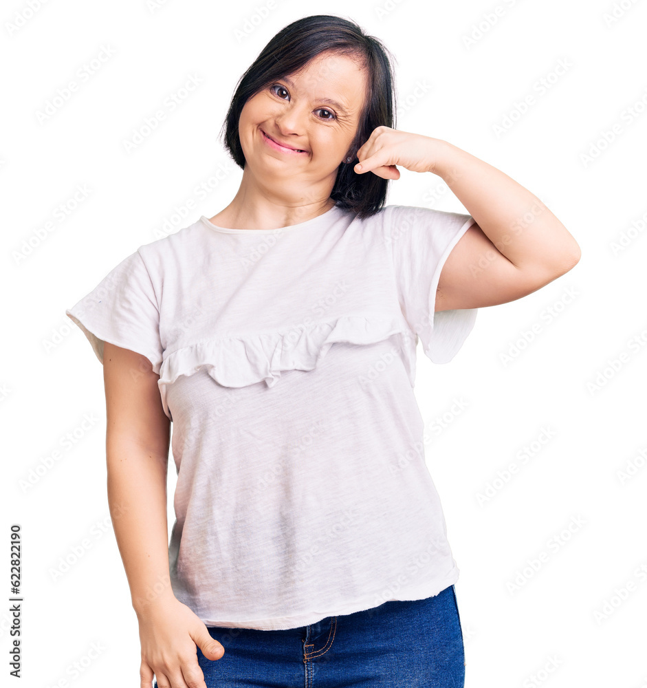 Fototapeta premium Brunette woman with down syndrome wearing casual white tshirt smiling doing phone gesture with hand and fingers like talking on the telephone. communicating concepts.