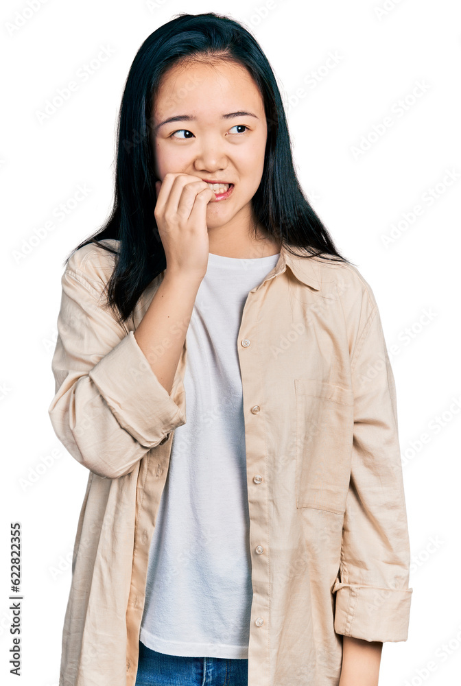 Young chinese woman wearing casual white t shirt and jacket looking stressed and nervous with hands on mouth biting nails. anxiety problem. Young chinese woman wearing casual white t shirt and jacket looking stressed and nervous with hands on mouth biting nails. anxiety problem.