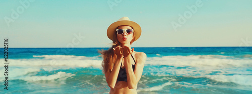 Canvas Print Summer vacation, beautiful happy woman blowing her lips sends air kiss in bikini