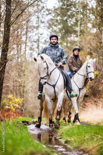 Horse riding, Way of st James in Fragas do Eume, Galicia. Hispanic pilgrim mid couple equitation