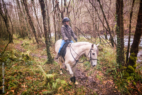 Horse riding, Way of st James in Fragas do Eume, Galicia. Hispanic woman pilgrim equitation © Sangiao_Photography