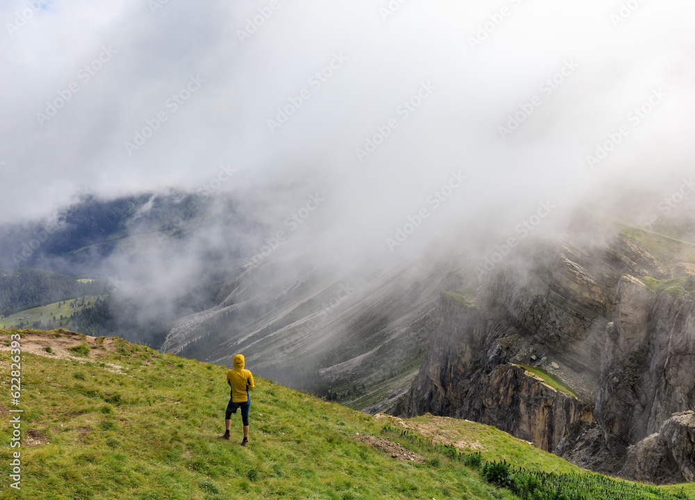 Person standing at Seceda mountain ridgeline in Dolomites, Italy