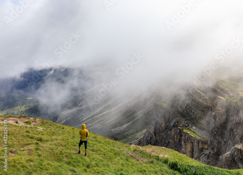 Person standing at Seceda mountain ridgeline in Dolomites, Italy