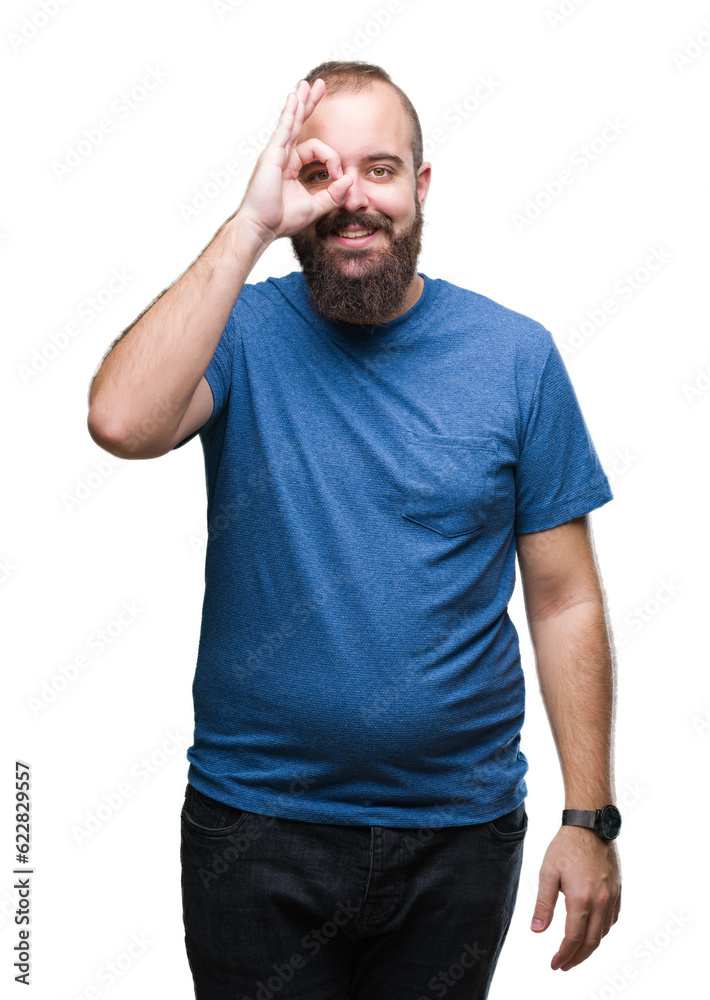Young caucasian hipster man over isolated background doing ok gesture with hand smiling, eye looking through fingers with happy face. Young caucasian hipster man over isolated background doing ok gesture with hand smiling, eye looking through fingers with happy face.