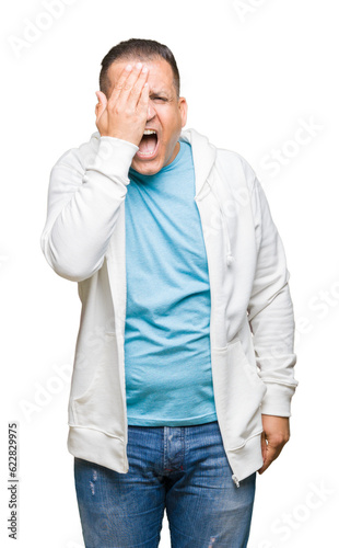 Middle age arab man wearing sweatshirt over isolated background covering one eye with hand with confident smile on face and surprise emotion. © Krakenimages.com