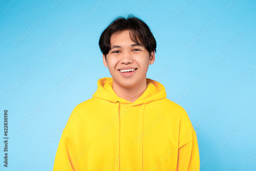Portrait Of Young Smiling Asian Guy Posing Over Blue Background Portrait Of Young Smiling Asian Guy Posing Over Blue Background
