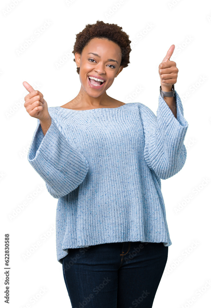 Young beautiful african american woman wearing a sweater over isolated background approving doing positive gesture with hand, thumbs up smiling and happy for success. Looking at the camera